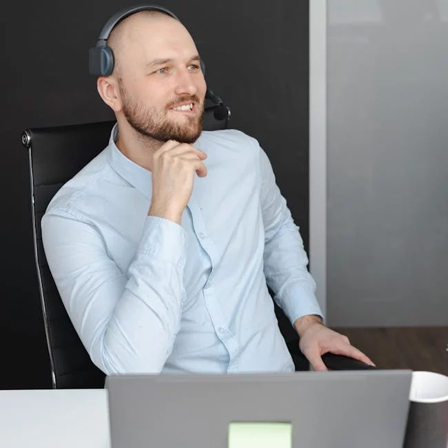 Professional man sitting at a desk with a laptop, thoughtfully planning strategy and reviewing business ideas.