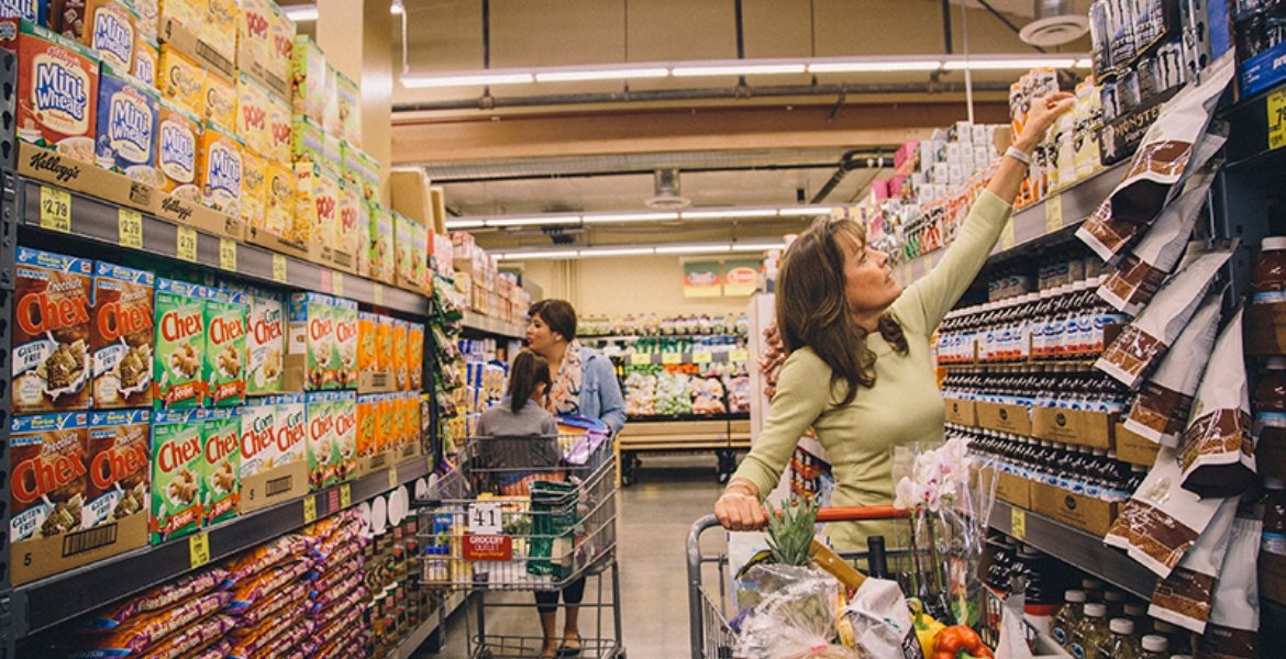 A fully stocked Grocery Outlet aisle filled with colorful products and discount signage, showcasing wide selection and savings.